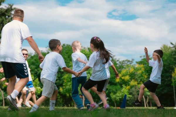 Group of children having fun and playing games together in a sunny park.
